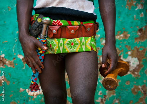 Tribe man holding his headrest with mobile phone and knife, Key afer, Omo valley, Ethiopia photo