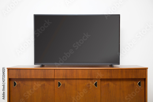 Modern TV set with empty blank screen on the wooden cabinet