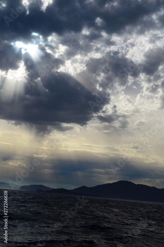 the setting sun in the clouds over the Aegean Sea