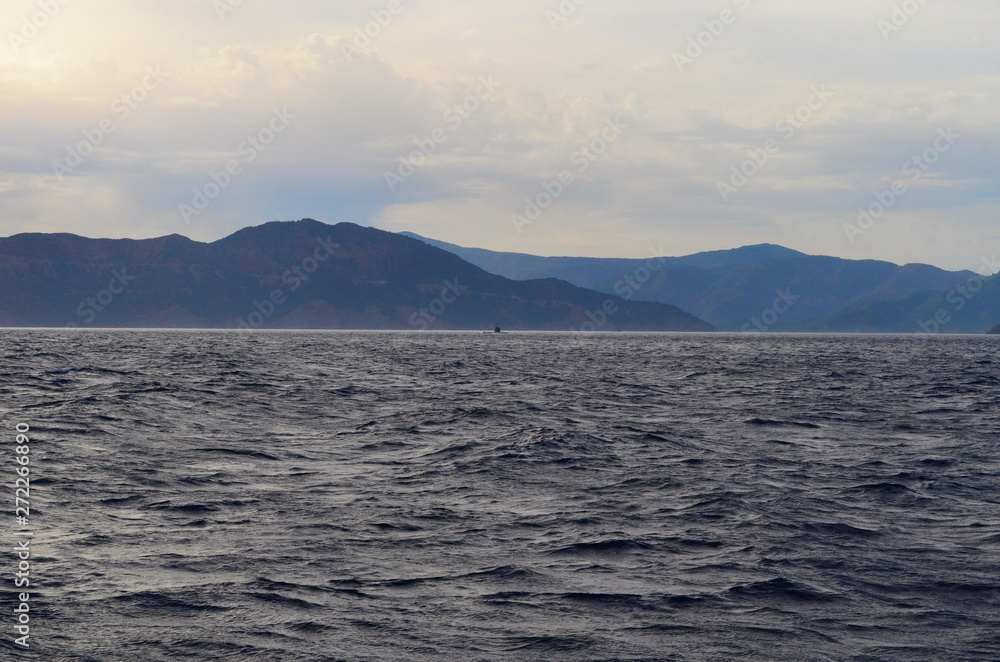 the setting sun in the clouds over the Aegean Sea