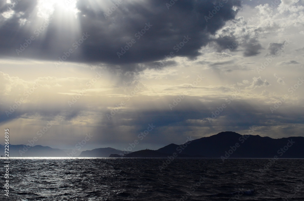 the setting sun in the clouds over the Aegean Sea the setting sun in the clouds over the Aegean Sea