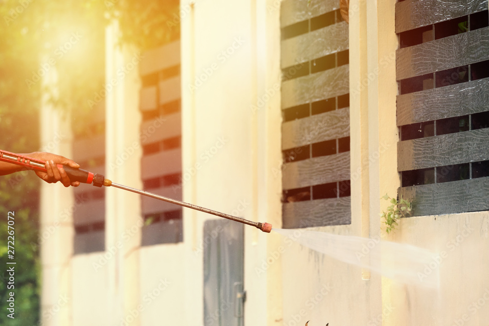 High pressure cleaning,side view..Man hand holding pipeline of high pressure cleaning machine