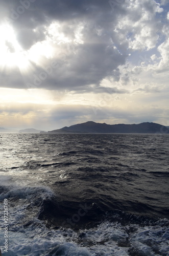 the setting sun in the clouds over the Aegean Sea