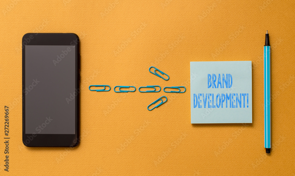 Writing note showing Brand Development. Business concept for Defining the product to excel in the market Promoting Colored sticky note clips smartphone pen trendy cool pastel background Writing note showing Brand Development. Business concept for Defining the product to excel in the market Promoting Colored sticky note clips smartphone pen trendy cool pastel background