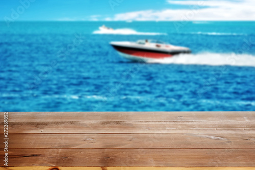 wood dock on lake with power boats