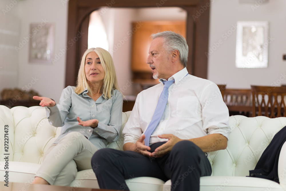Happy mature couple talking in their home Happy mature couple talking in their home