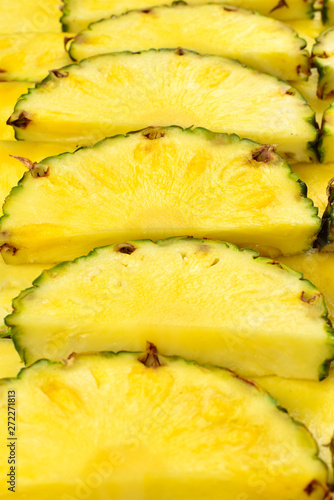 Pineapple juicy yellow slices background. Top view.