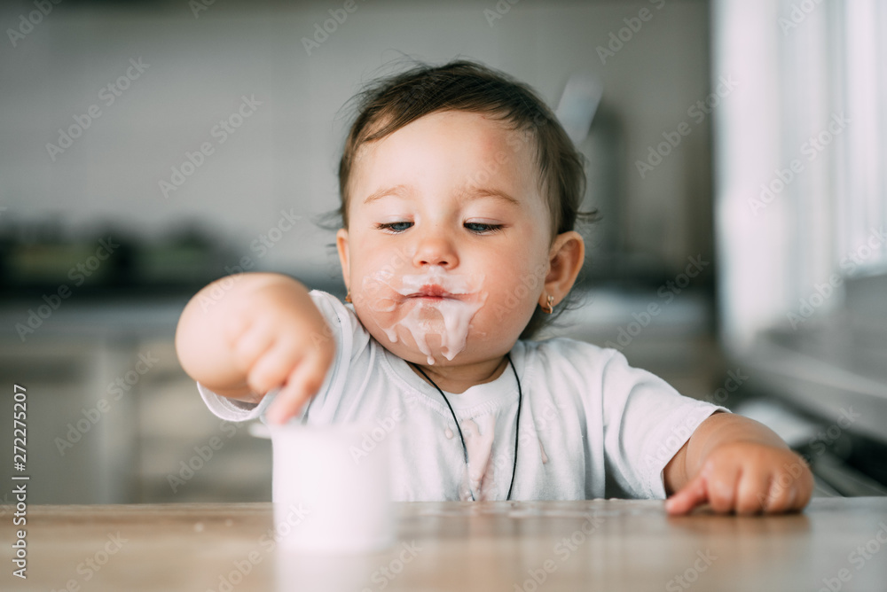 A little charming girl eats yogurt all smeared herself A little charming girl eats yogurt all smeared herself