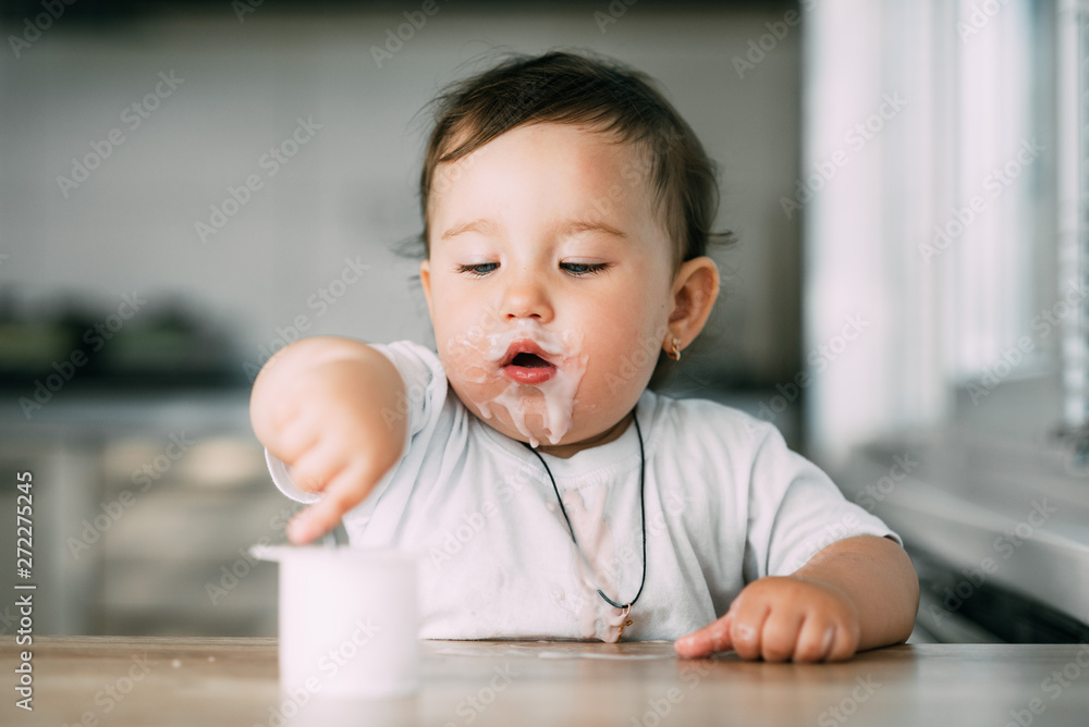 A little charming girl eats yogurt all smeared herself A little charming girl eats yogurt all smeared herself