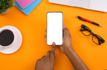 Woman using blank smartphone on orange background