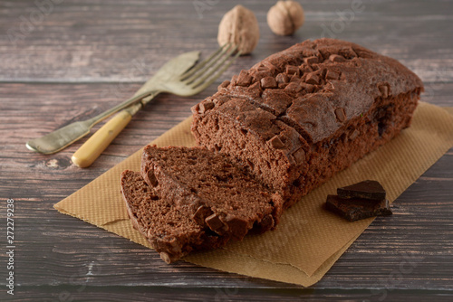Foto Piece of chocolate cake , fudge or pound cake. Wooden background.