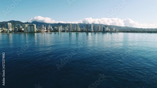 Flying over a boat being towed, with Waikiki beach in the background. photo