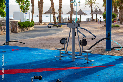urban sport simulator in outdoor city square for activities on fresh air with palm park and coast line scenic landscape background 