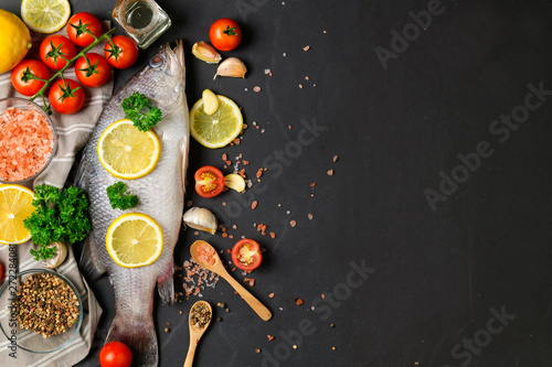 Fresh fish seabass and ingredients for cooking.