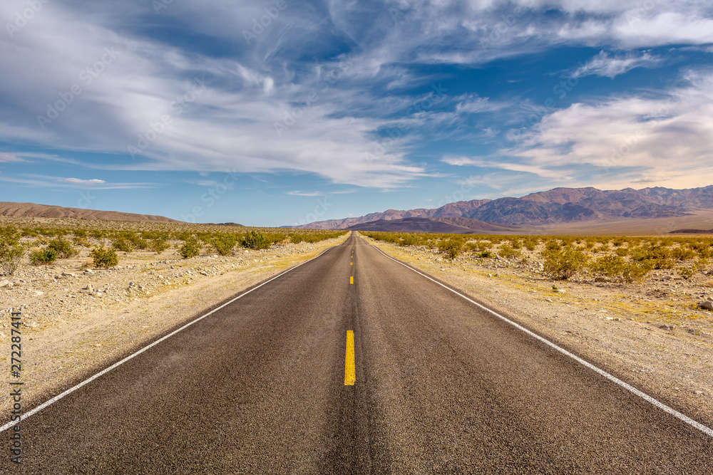 Road through a desert and mountains in California, USA