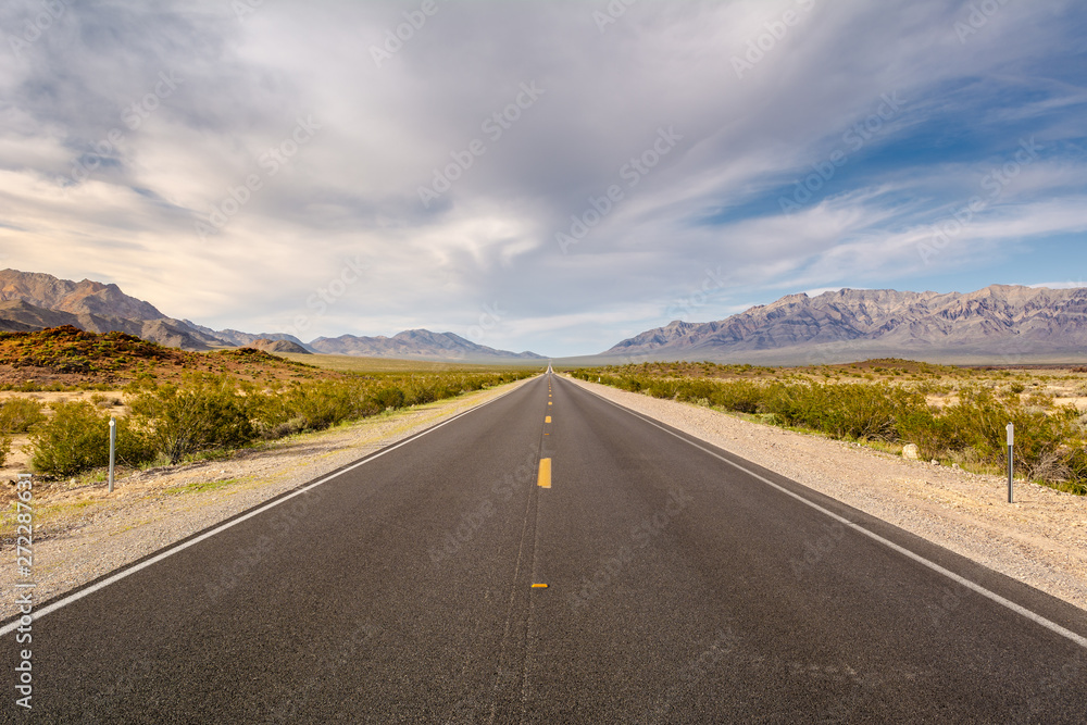 Road through a desert and mountains in California, USA