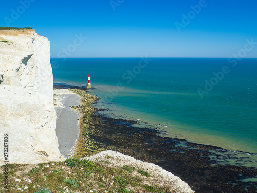 View of the white chalk headland cliffs and Beachy Head Lighthouse in Seven Sisters National park, Eastbourne, East Sussex, England, UK.