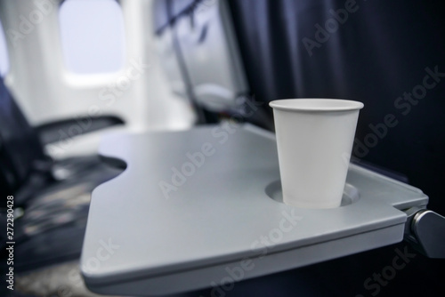 plastic cup on the table in the plane during the flight. alcohol consumption on board