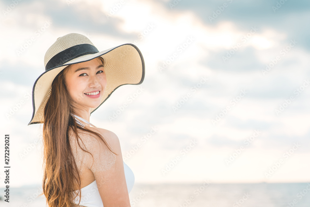 Attractive Asian young woman wearing white bikini smile enjoy with summer vacation on the beach feeling so happiness and cheerful,Travel in tropical beach in Thailand,vacations and relaxation Concept