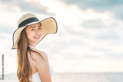 Attractive Asian young woman wearing white bikini smile enjoy with summer vacation on the beach feeling so happiness and cheerful,Travel in tropical beach in Thailand,vacations and relaxation Concept