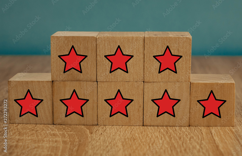 Red stars on wooden cubes on a blue background. Stars mean assessing quality. five-point rating system.