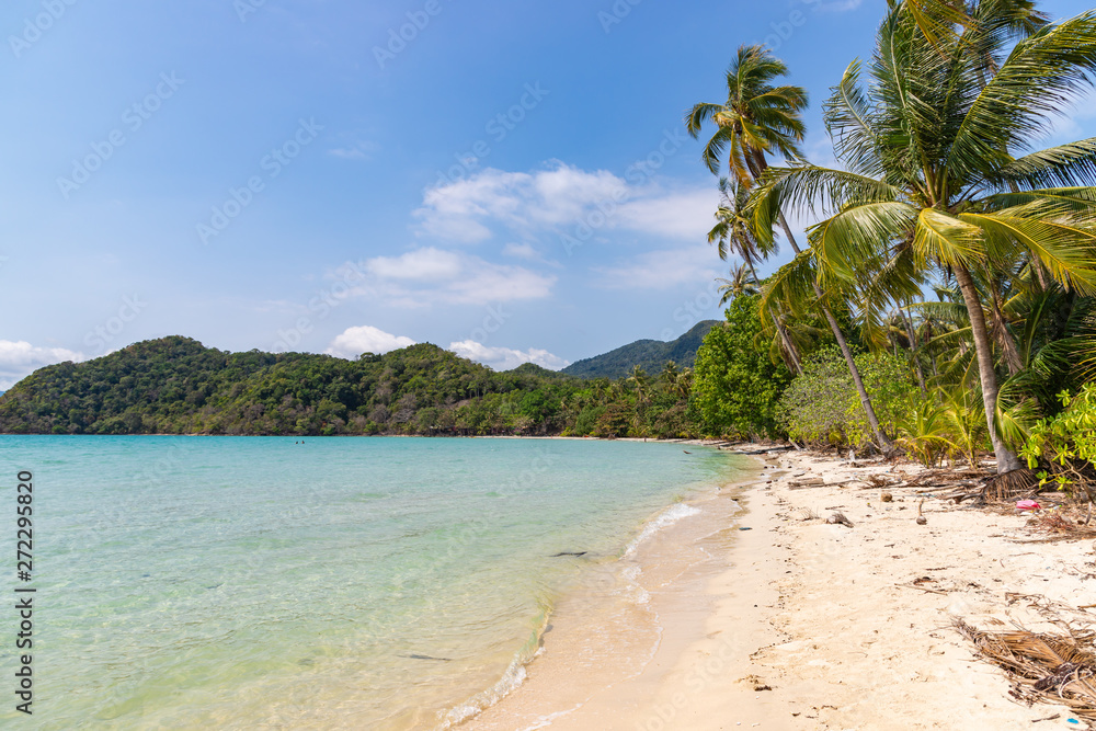 Fototapeta Long beach of Koh Chang island. Tropical sandy beach with palm trees and tropical forest. Thailand.
