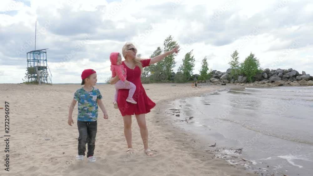 Young mother with children walking by the sea Young mother with children walking by the sea