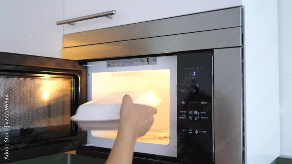 Woman's Hands Preparing Food At Home Using Microwave Woman's Hands Preparing Food At Home Using Microwave
