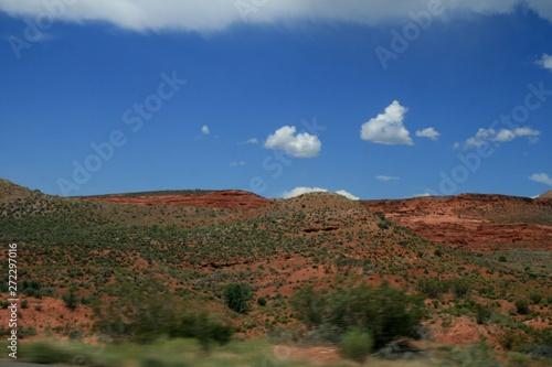 USA. Red mountains Utah. Gray Mountains in Utah. View from the highway from car. Spring, fine weather. Grass on the rocks