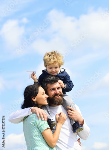 Father and his son child boy playing outdoors. Parenting. Happy father giving son back ride on sky in summer.