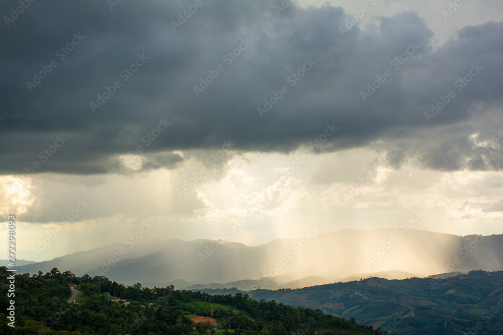 Heavy dark storm raining clouds over the sky above mountain range.