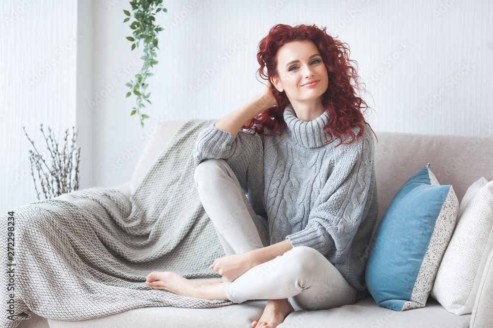 Obraz premium Closeup portrait of young beautiful redhaired woman. Redhead female indoors. Beauty portrait of attractive lady at home with free space.