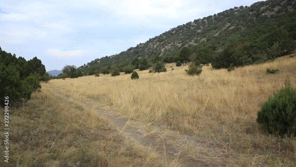 Hiking trail on Caraul-Oba mountain. Path through field of dry grass. Crimea, Novyi Svit. Hiking trail on Caraul-Oba mountain. Path through field of dry grass. Crimea, Novyi Svit.