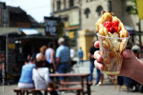 Bubble waffles with ice cream in hand. Hong kong waffle . Bubble waffles with strawberries, whipped cream and marshmallow are sold on Open kitchen food festival event.