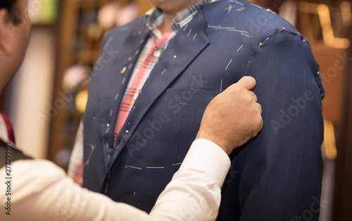 Tailor working with custom made suit