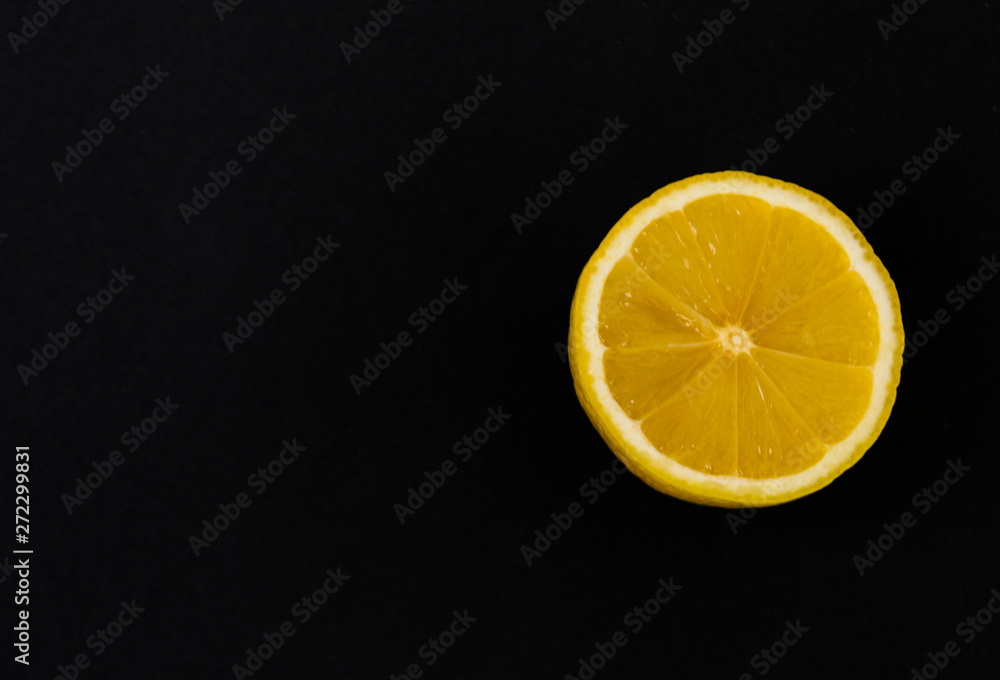 Round slice of yellow lemon, on a black background. Round slice of yellow lemon, on a black background.
