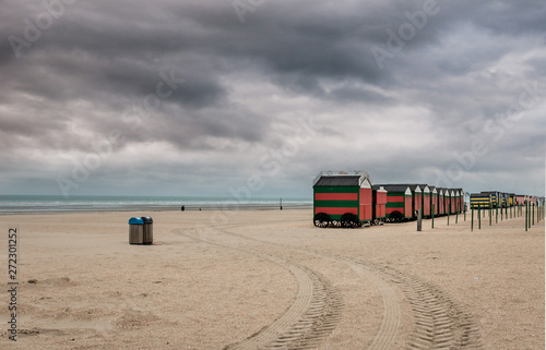 Row of colorful beach huts on a cloudy day photo