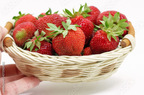  strawberries in a wicker basket on a white background