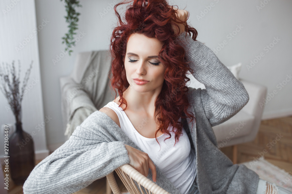 Naklejka premium Closeup portrait of young beautiful redhaired woman. Redhead female indoors. Beauty portrait of attractive lady at home with free space.