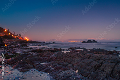 View of the beautiful sunset over False Bay from Kalkbay, with mountains in the background, Cape Town, South Africa photo