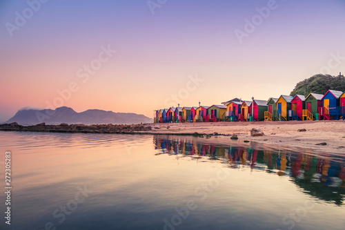 View of the beautiful sunset over False Bay from Kalkbay with little coloured houses on the beach, with mountains in the background, Cape Town, South Africa photo