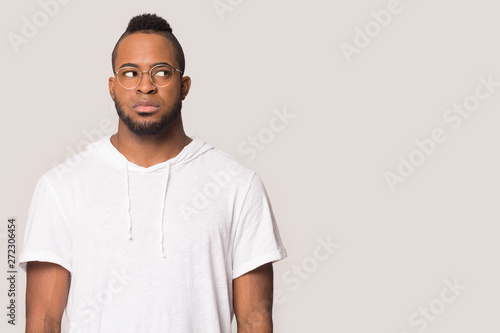 Motionless african afraid guy looks aside at copyspace studio shot