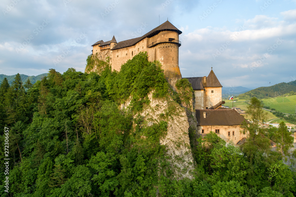 Orava castle - Oravsky Hrad in Oravsky Podzamok in Slovakia. Medieval stronghold on extremely high and steep cliff. Aerial view in summer at sunset