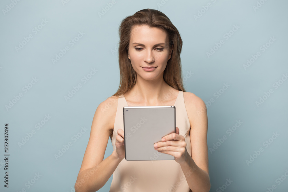 Confident young woman using tablet computer, reading book, chatting Confident young woman using tablet computer, reading book, chatting