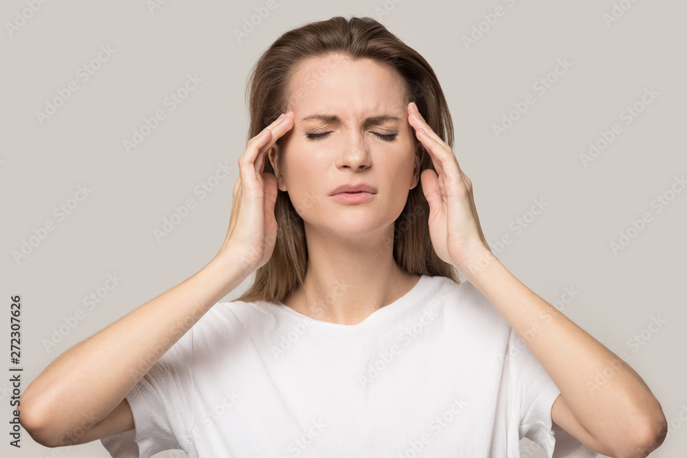 Unhappy tired young woman touching temples, suffering from headache Unhappy tired young woman touching temples, suffering from headache