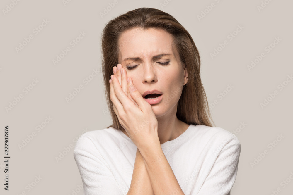 Unhappy young woman suffering from toothache, touching cheek Unhappy young woman suffering from toothache, touching cheek