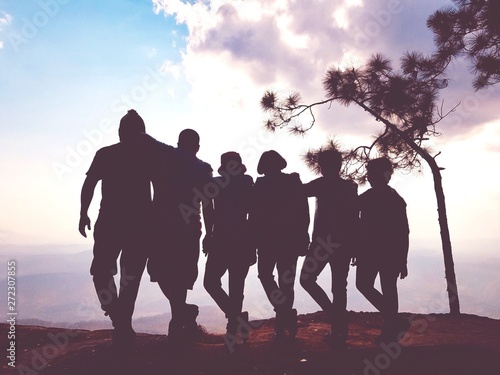 group of people or family or friend on a hill in silhouette style or shadow.