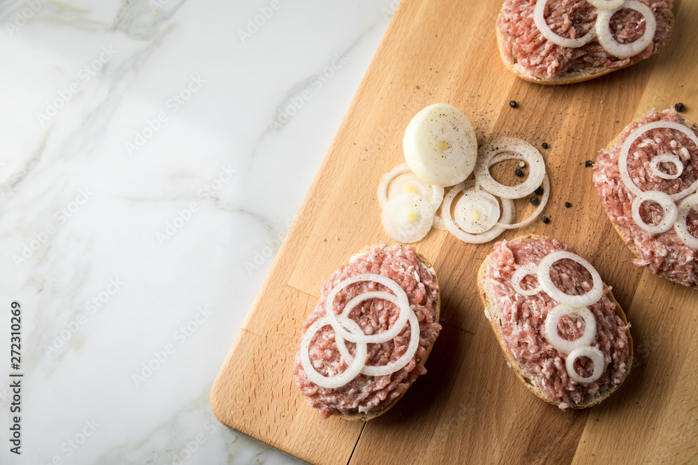 Deutsche Mettbrötchen mit rohen Schweine Mett, Brötchen, Butter, Zwiebeln, Pfeffer und Mett auf
