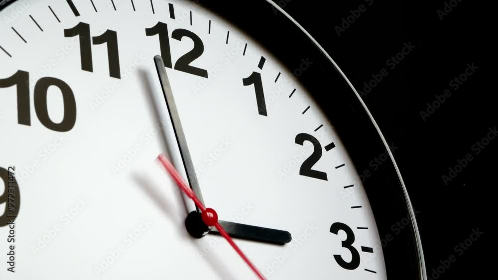 The Time On The Clock Three. Black Clock With The Red Arrow Running In The Background Of The Arabic Numerals