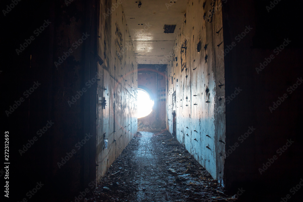 Creepy corridor in abandoned nuclear power plant with light from round hole Creepy corridor in abandoned nuclear power plant with light from round hole